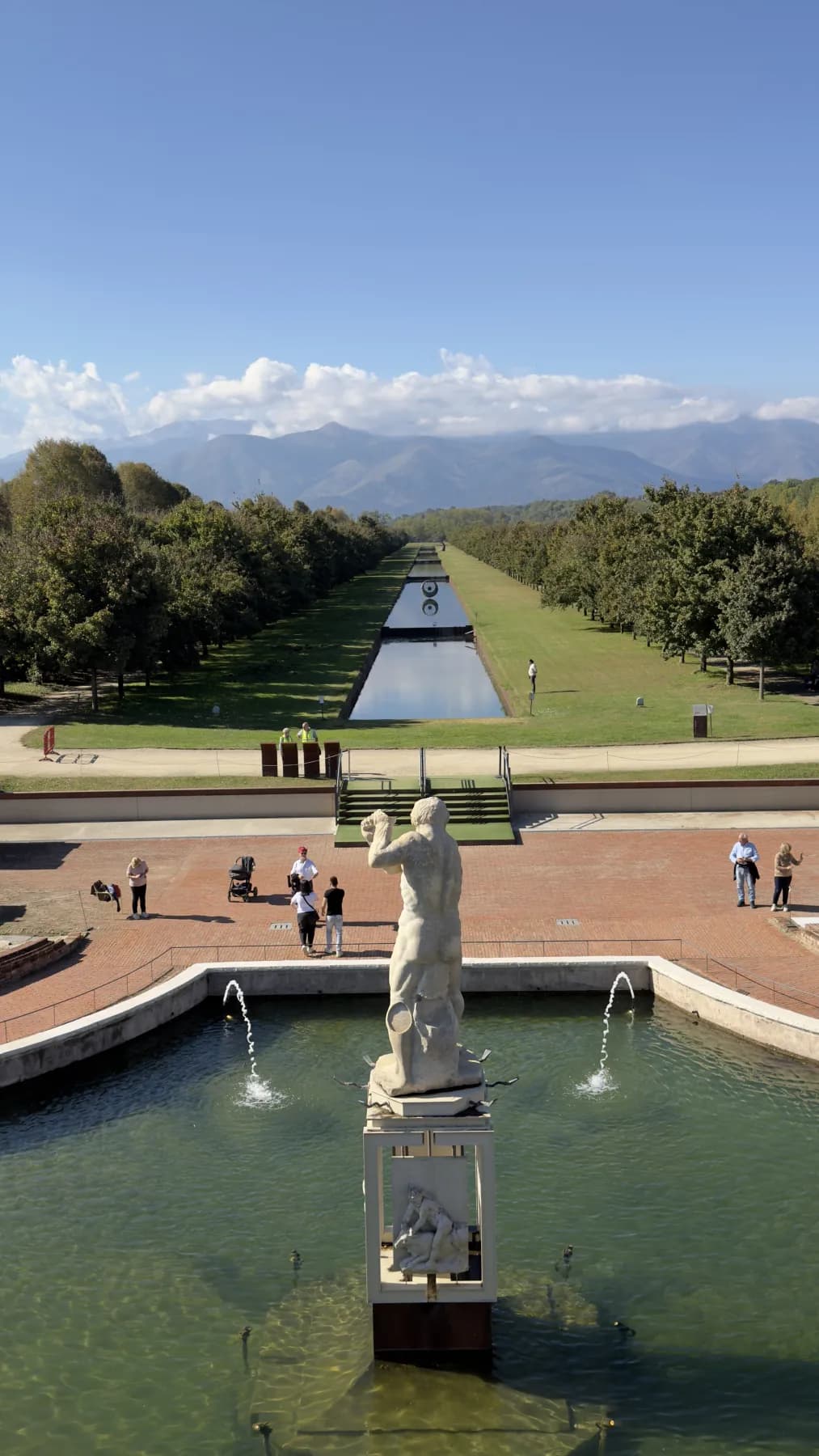La fontana dei Giardini della Reggia con il canale e le Alpi sullo sfondo