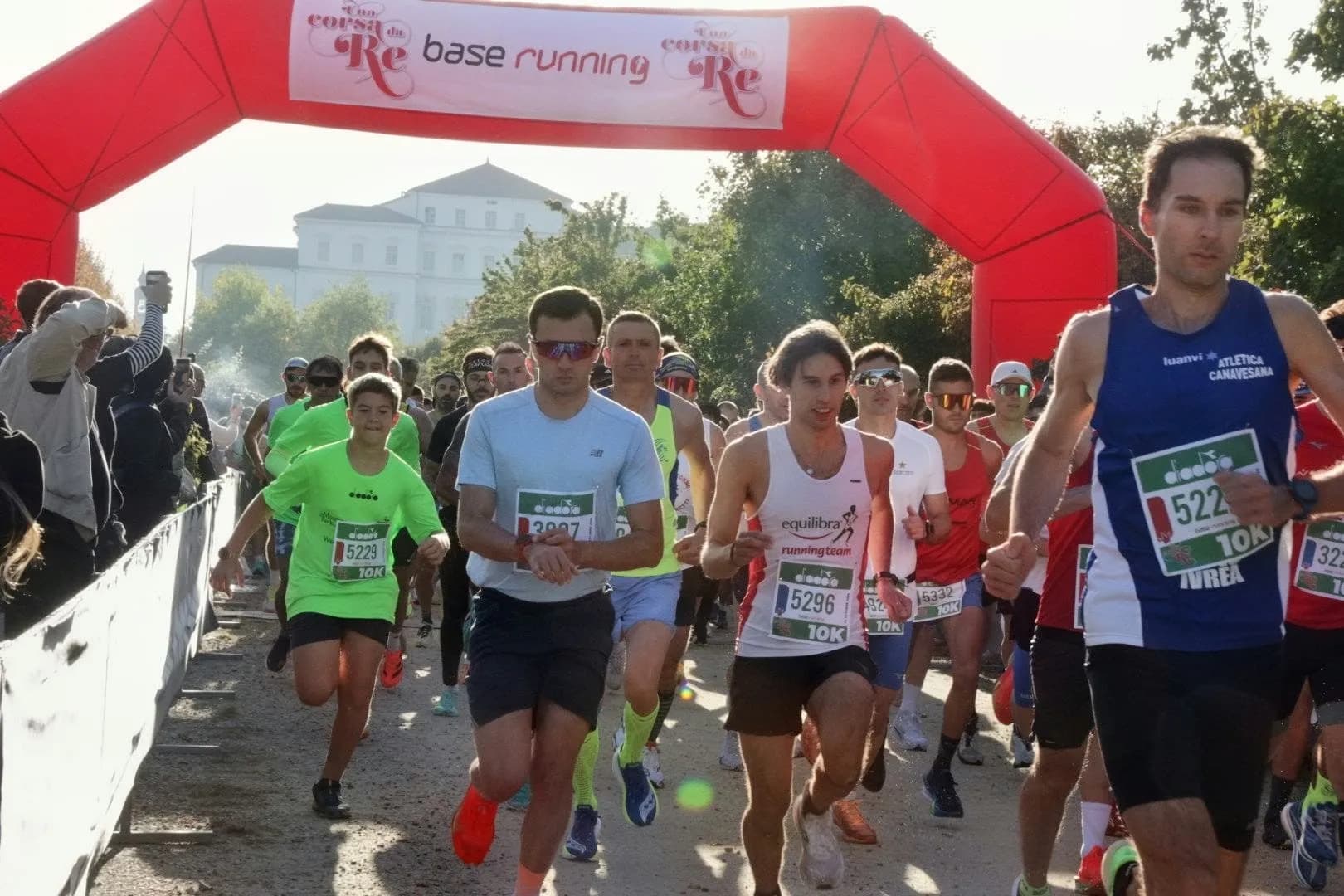 La salida de los 10 km bajo el arco rojo, con la Reggia al fondo
